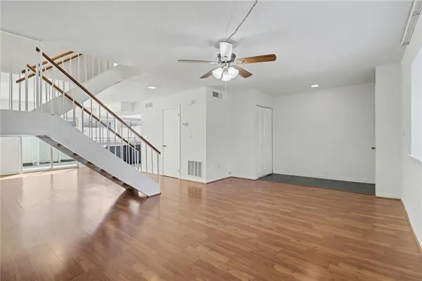 a view of an empty room with a window and wooden floor