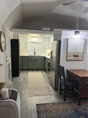 a large kitchen with stainless steel appliances kitchen island granite countertop a table and chairs in it