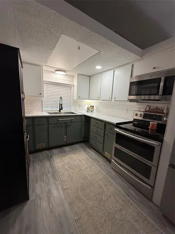 a kitchen with stainless steel appliances granite countertop a sink and a stove