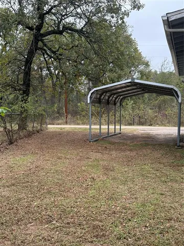 a view of backyard with a table and chairs under an umbrella