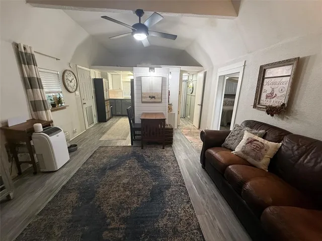 a living room with furniture a large window and a chandelier