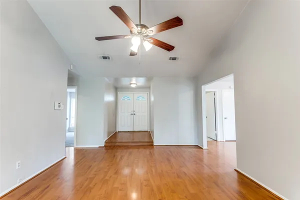 a view of empty room with wooden floor