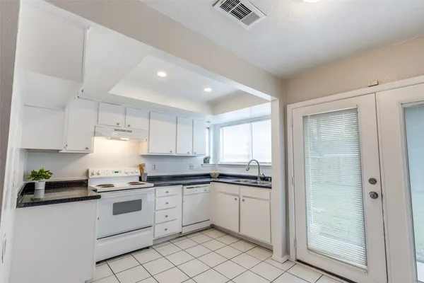 a kitchen with white cabinets stainless steel appliances and a sink