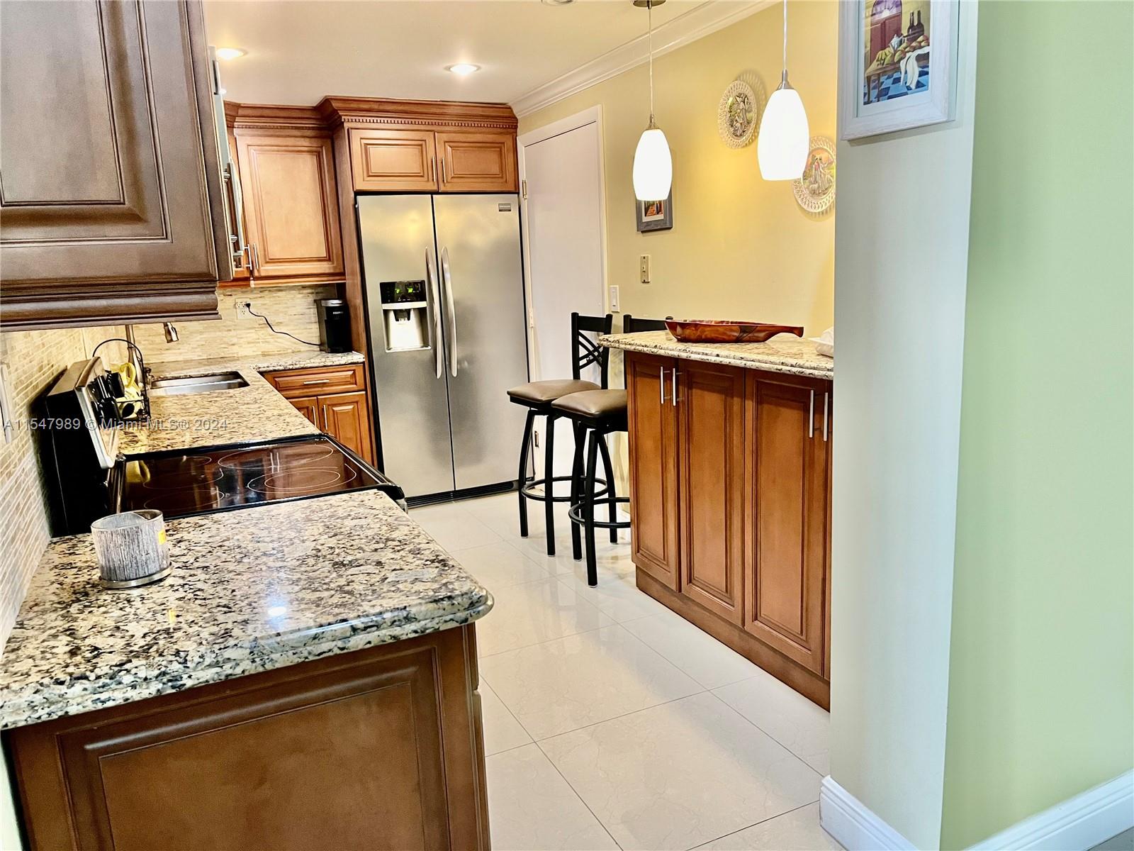 a kitchen with stainless steel appliances granite countertop a sink refrigerator and stove