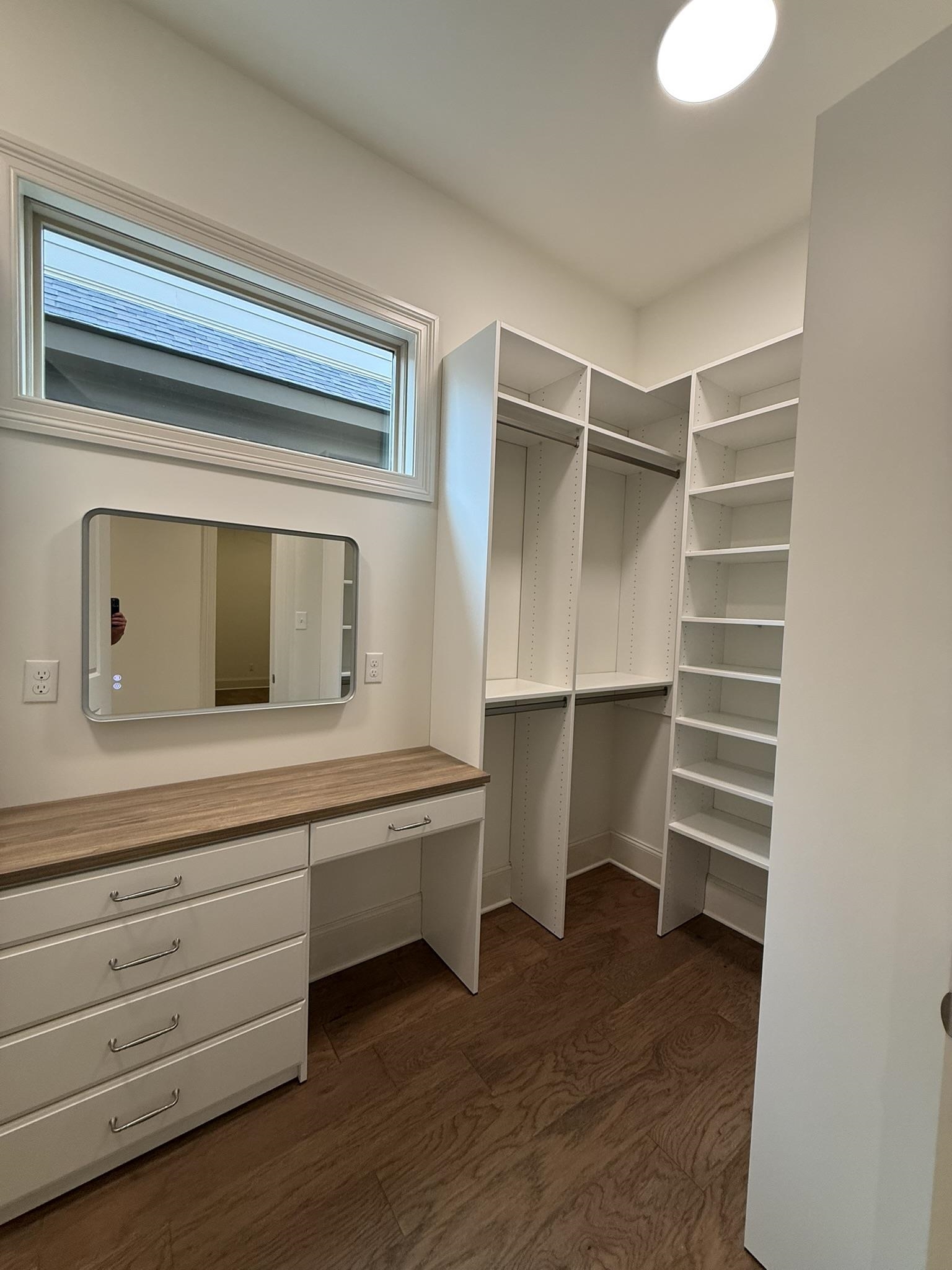 10132 Rokeby Farm Lane Collierville, TN 38017 - Photo 14 of 24 Custom closet system featuring shelving, hanging rods, built-in dresser with wood-finish countertop, and a vanity area