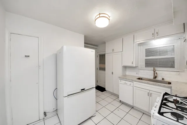 a kitchen with white cabinets and white appliances