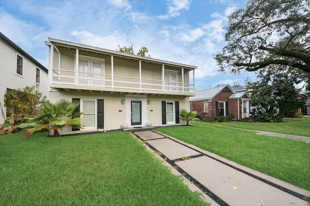 a front view of a house with a garden and trees