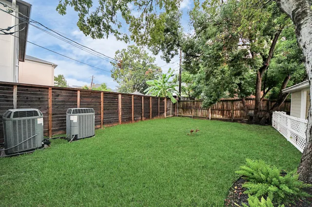 a view of a backyard with plants and wooden fence