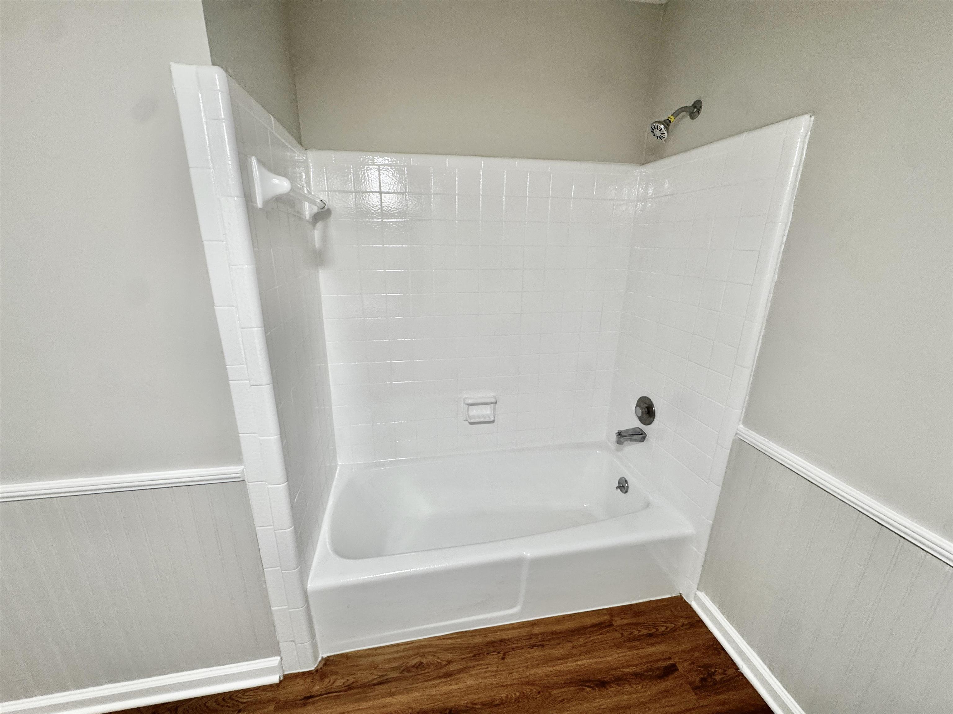 3334 Snow Ridge Cove Memphis, TN 38115 - Photo 13 of 38 Full bathroom featuring wainscoting, dark wood-type flooring, and shower / washtub combination