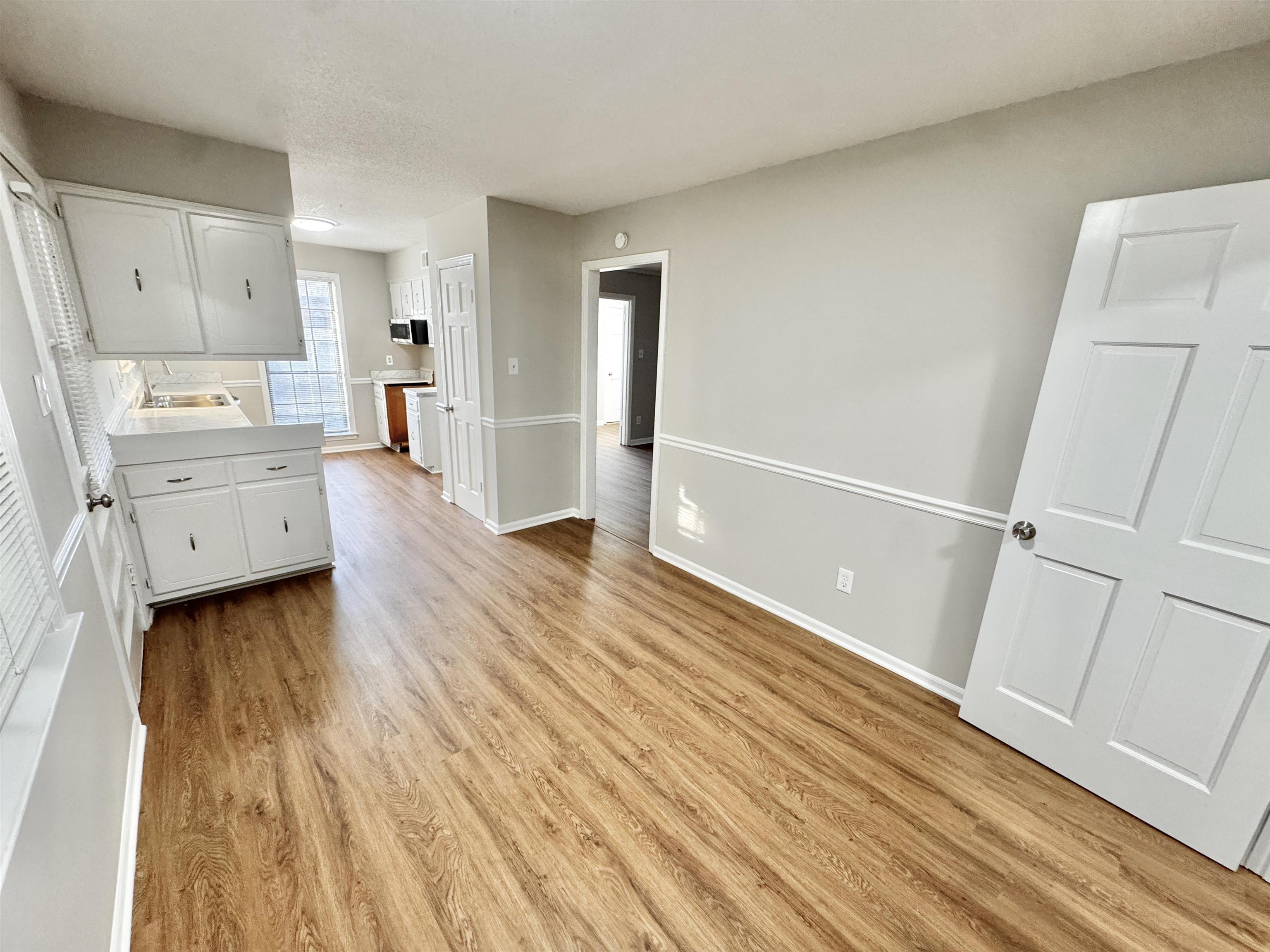 3334 Snow Ridge Cove Memphis, TN 38115 - Photo 14 of 38 Kitchen with white cabinets, light countertops, and light wood finished floors