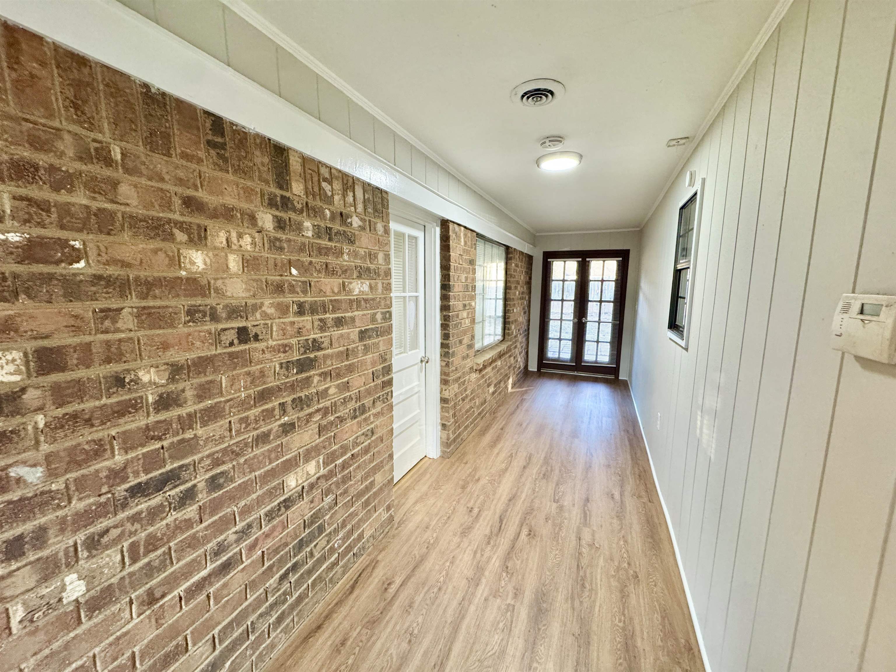 3334 Snow Ridge Cove Memphis, TN 38115 - Photo 21 of 38 Hallway featuring brick wall, wood finished floors, and ornamental molding