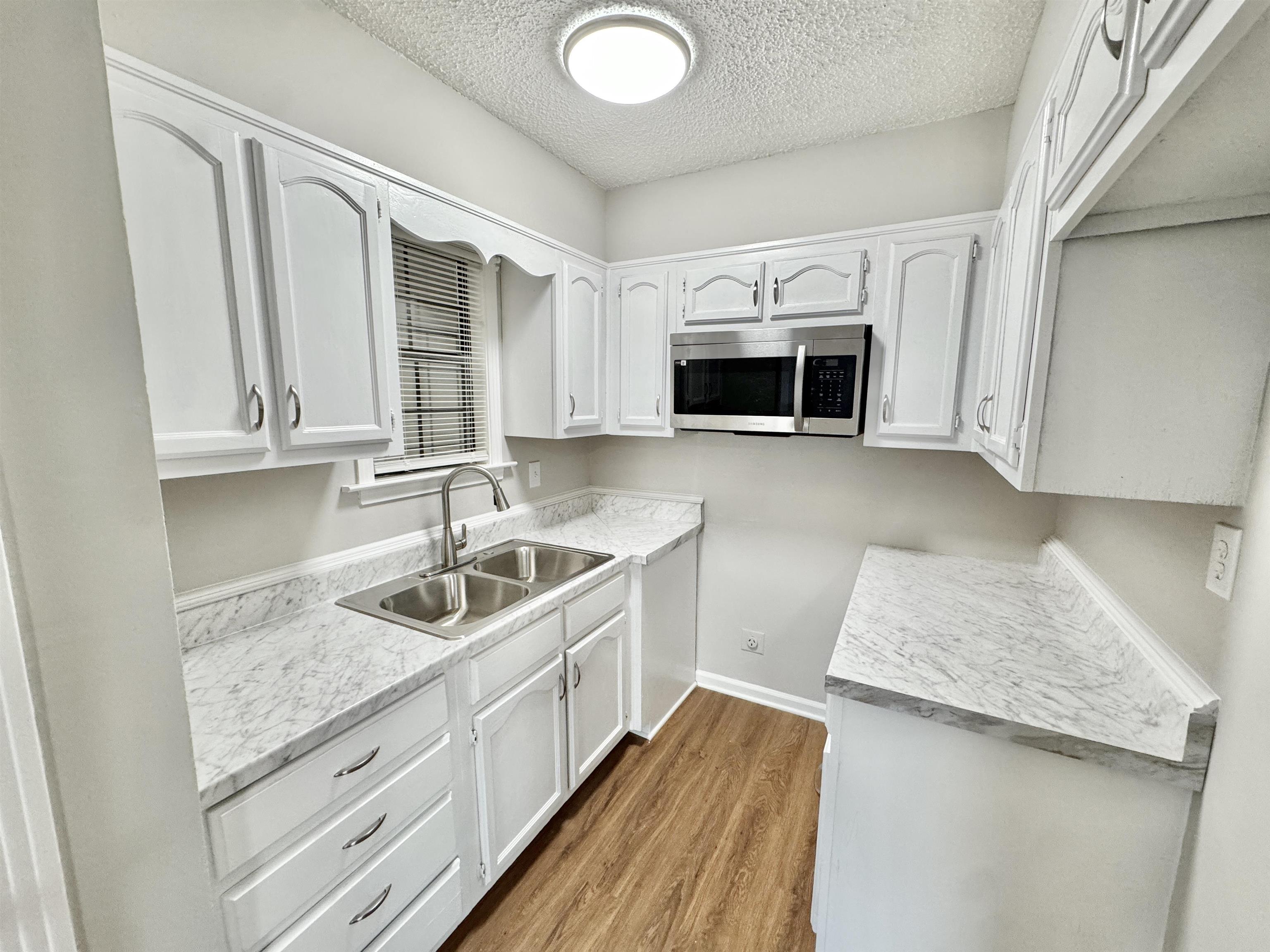 3334 Snow Ridge Cove Memphis, TN 38115 - Photo 22 of 38 a kitchen with granite countertop a sink a stove and cabinets