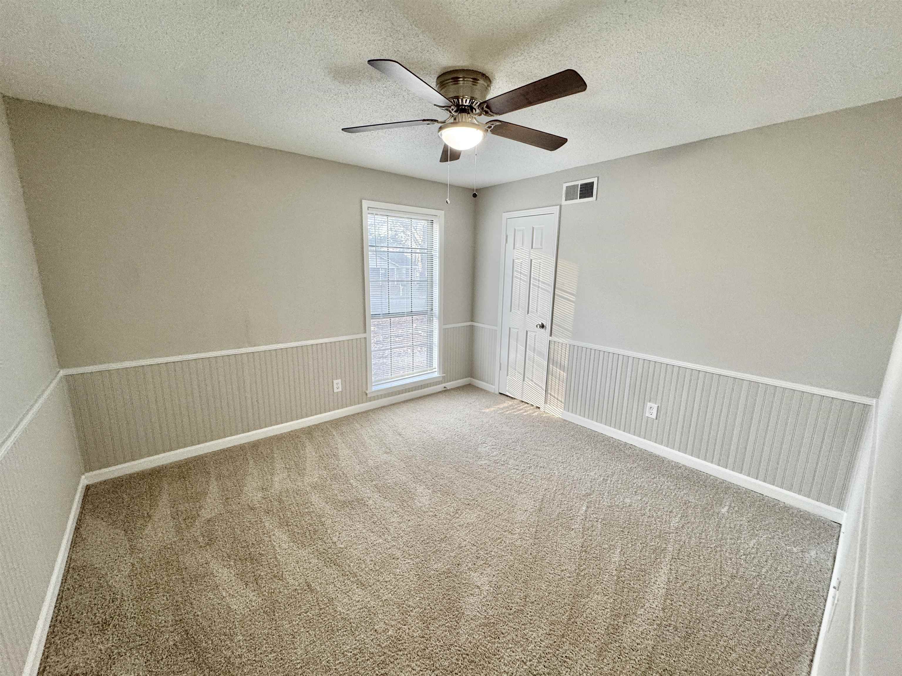 3334 Snow Ridge Cove Memphis, TN 38115 - Photo 8 of 38 Carpeted spare room with a textured ceiling, a wainscoted wall, and a ceiling fan