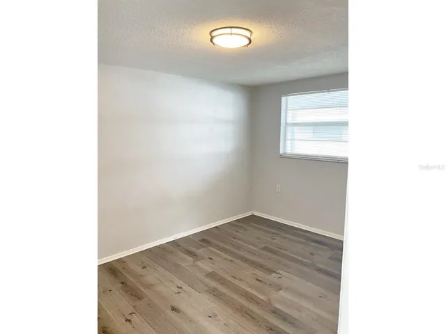 a view of a room with wooden floor and a window