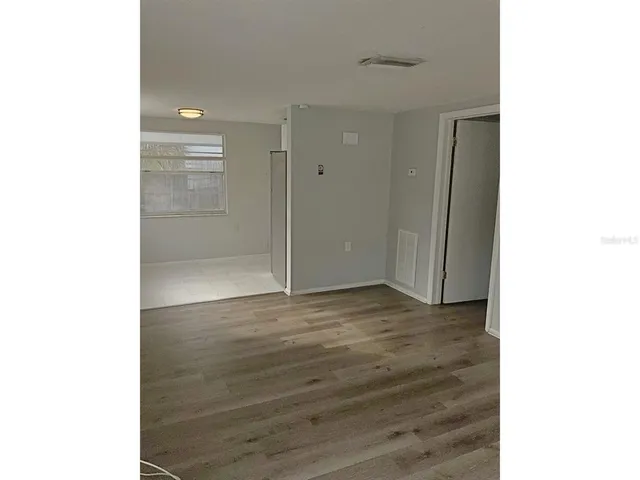 a view of an empty room with wooden floor