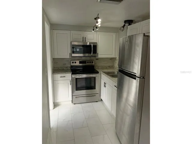 a kitchen with stainless steel appliances a refrigerator and a stove top oven