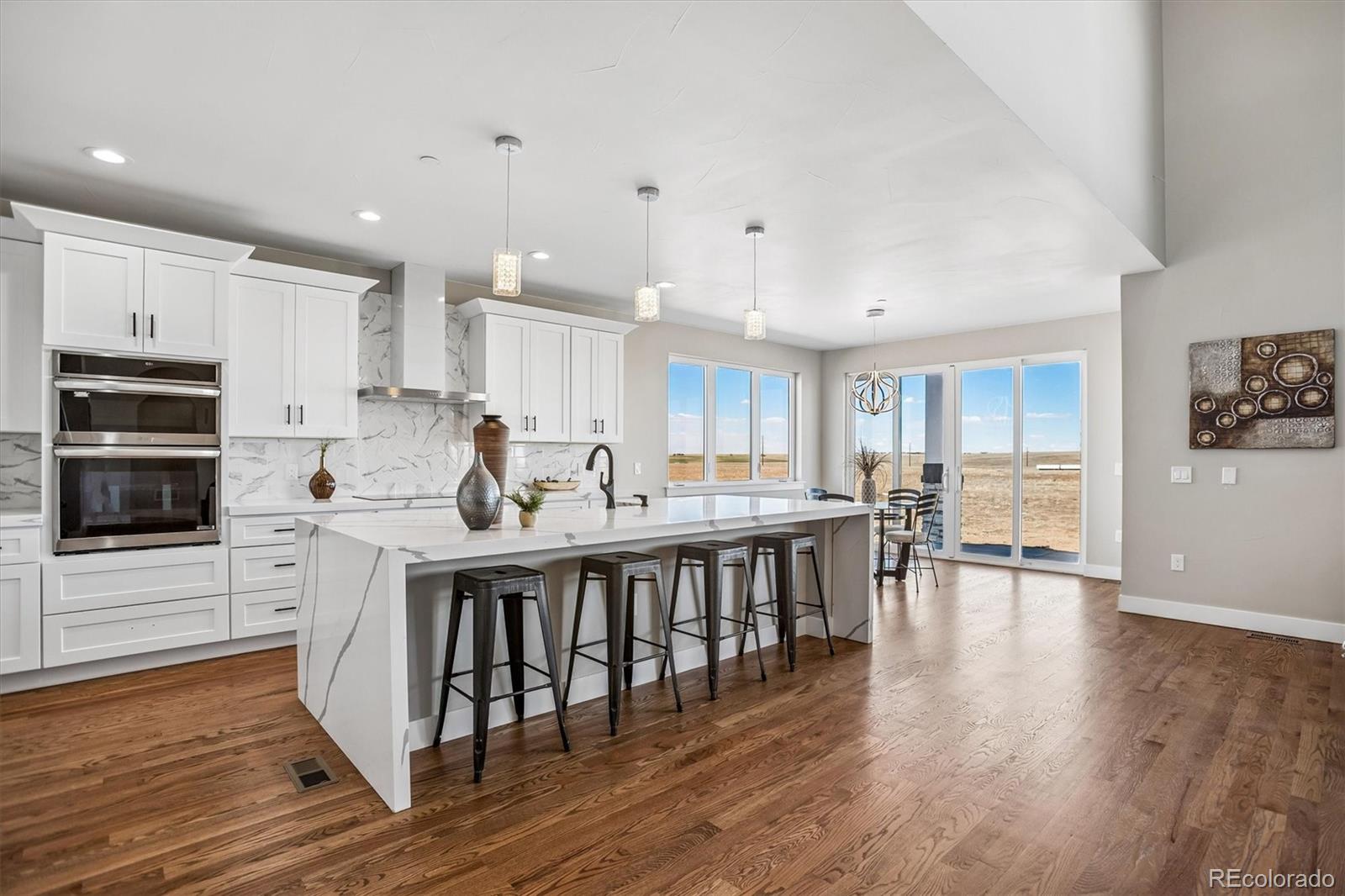 13350 Imboden Road Hudson, CO 80642 - Photo 6 of 50 a kitchen with stainless steel appliances granite countertop a table chairs microwave and sink
