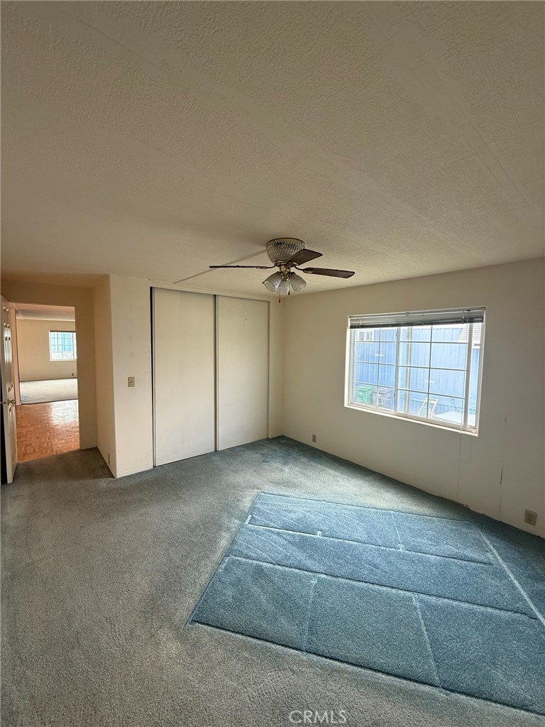 6508 Easy Street, Unit T Carlsbad, CA 92011 - Photo 11 of 19 an empty room with chandelier fan and windows