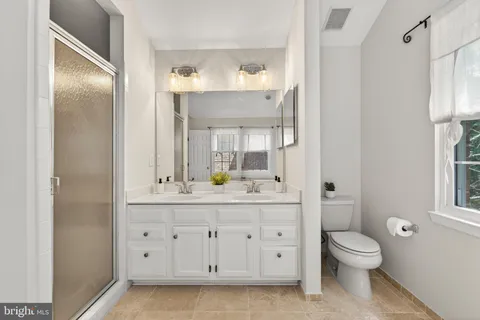 a bathroom with a granite countertop sink toilet a large mirror a vanity and