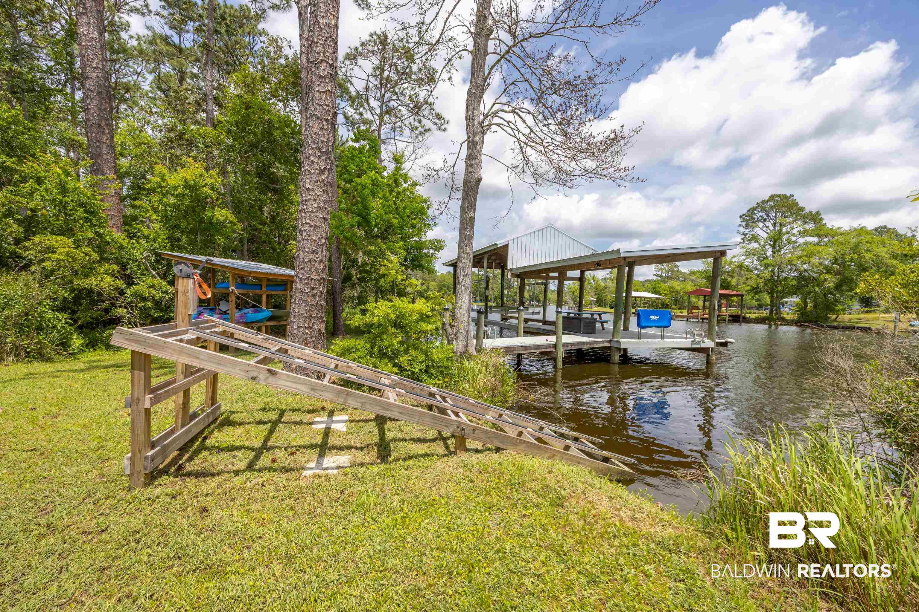 9771 Clarke Ridge Road Foley, AL 36535 - Photo 9 of 72 View of dock with boat lift, a yard, and a water view