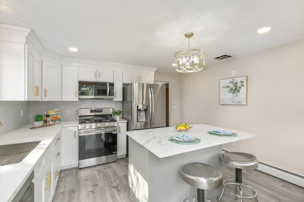 270 Lowell Street Wakefield, MA 01880 - Photo 15 of 41 a kitchen that has stainless steel appliances a table and chairs in it