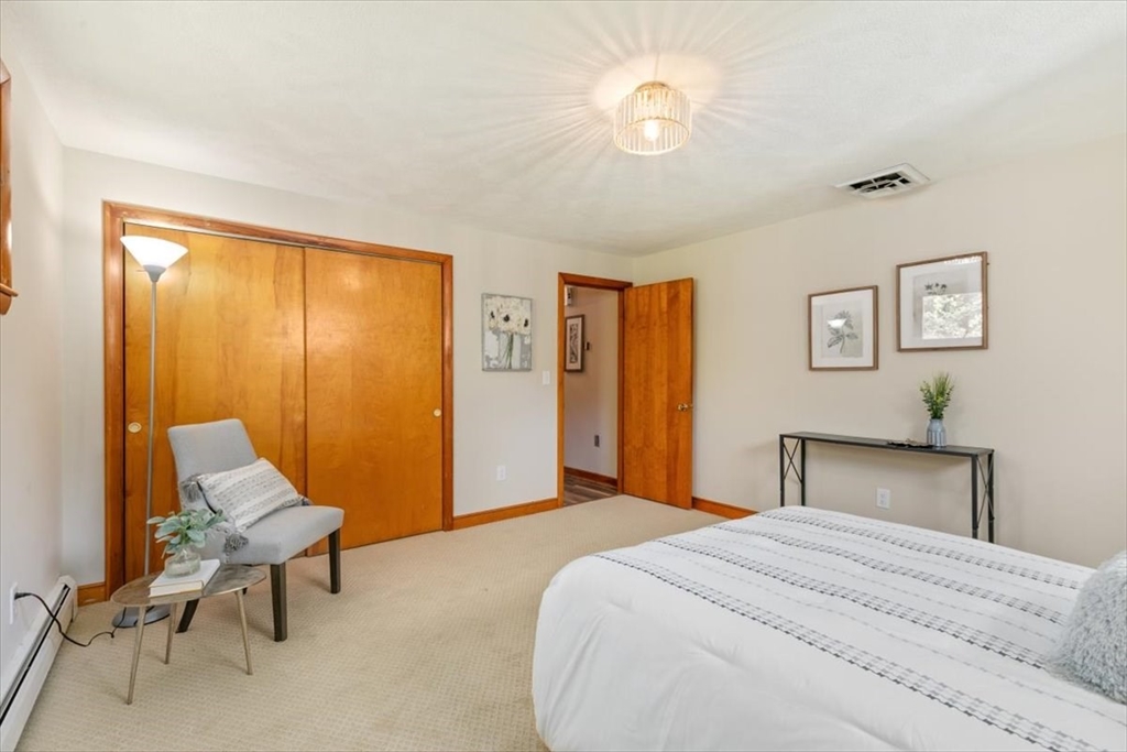 270 Lowell Street Wakefield, MA 01880 - Photo 20 of 41 a bedroom with a bed and a chandelier