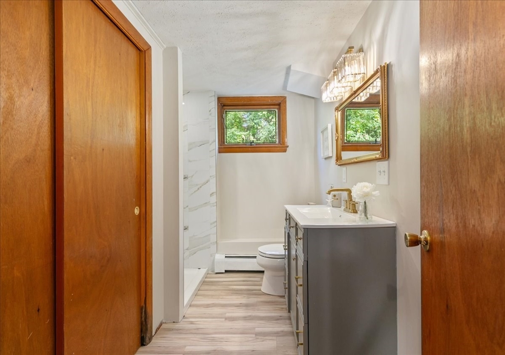 270 Lowell Street Wakefield, MA 01880 - Photo 31 of 41 a bathroom with a sink a toilet and a window