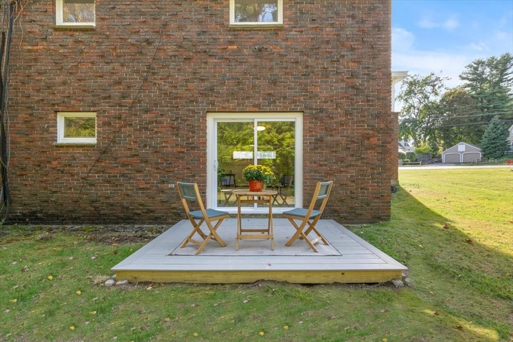 270 Lowell Street Wakefield, MA 01880 - Photo 40 of 41 a view of a white house with a yard potted plants and large tree