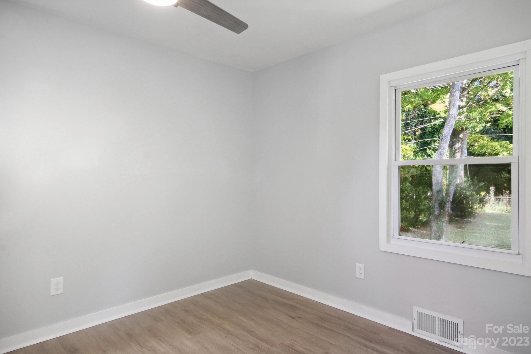 5225 Farmbrook Drive Charlotte, NC 28210 - Photo 12 of 18 an empty room with wooden floor and windows
