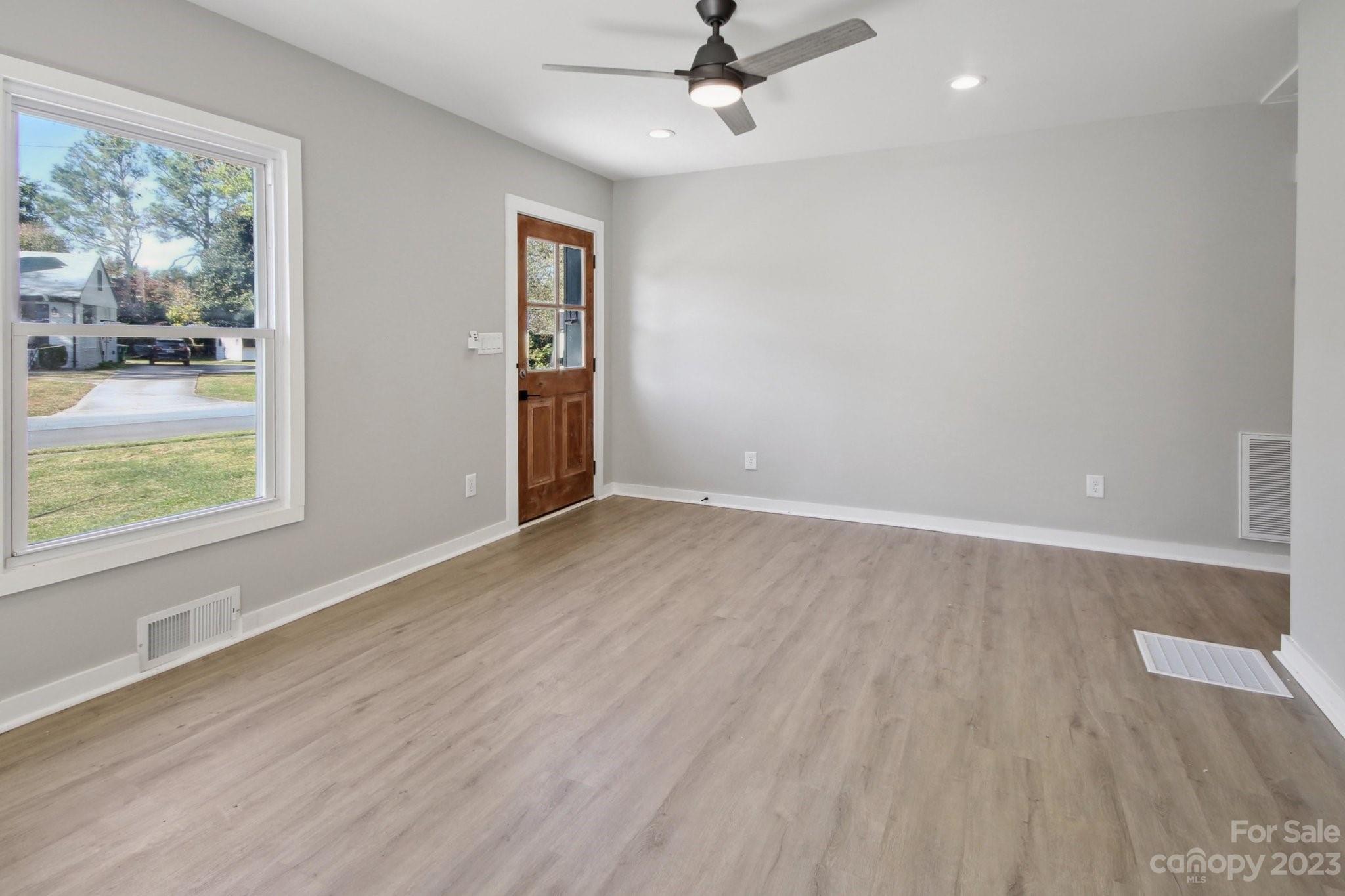 5225 Farmbrook Drive Charlotte, NC 28210 - Photo 3 of 18 an empty room with wooden floor fan and windows