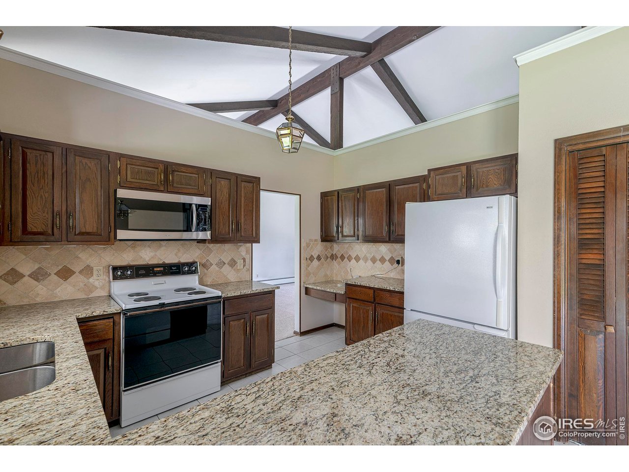 6844 Roaring Fork Trail Boulder, CO 80301 - Photo 11 of 37 a kitchen with stainless steel appliances granite countertop a stove refrigerator and a sink