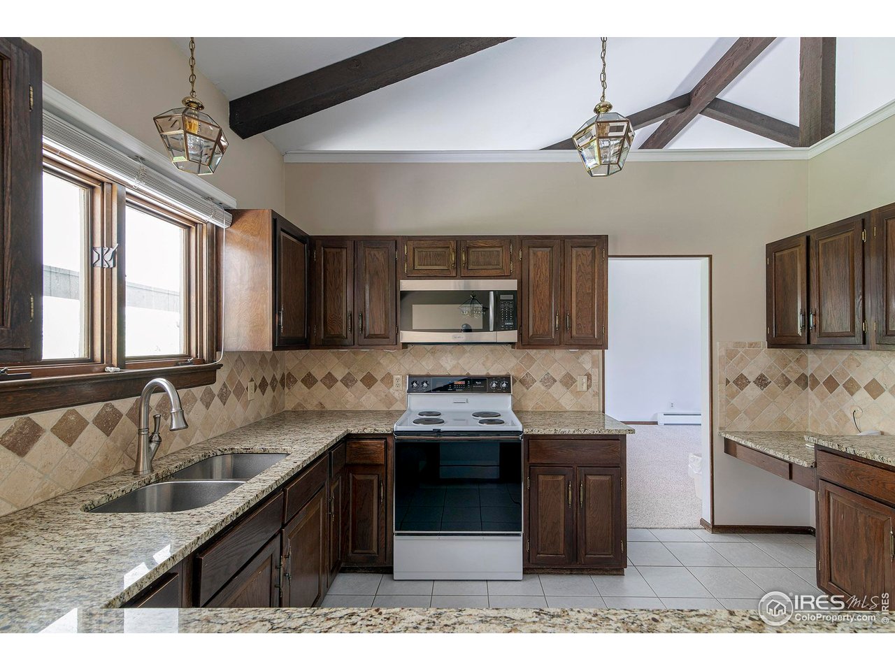 6844 Roaring Fork Trail Boulder, CO 80301 - Photo 12 of 37 a kitchen with stainless steel appliances granite countertop a sink and stove