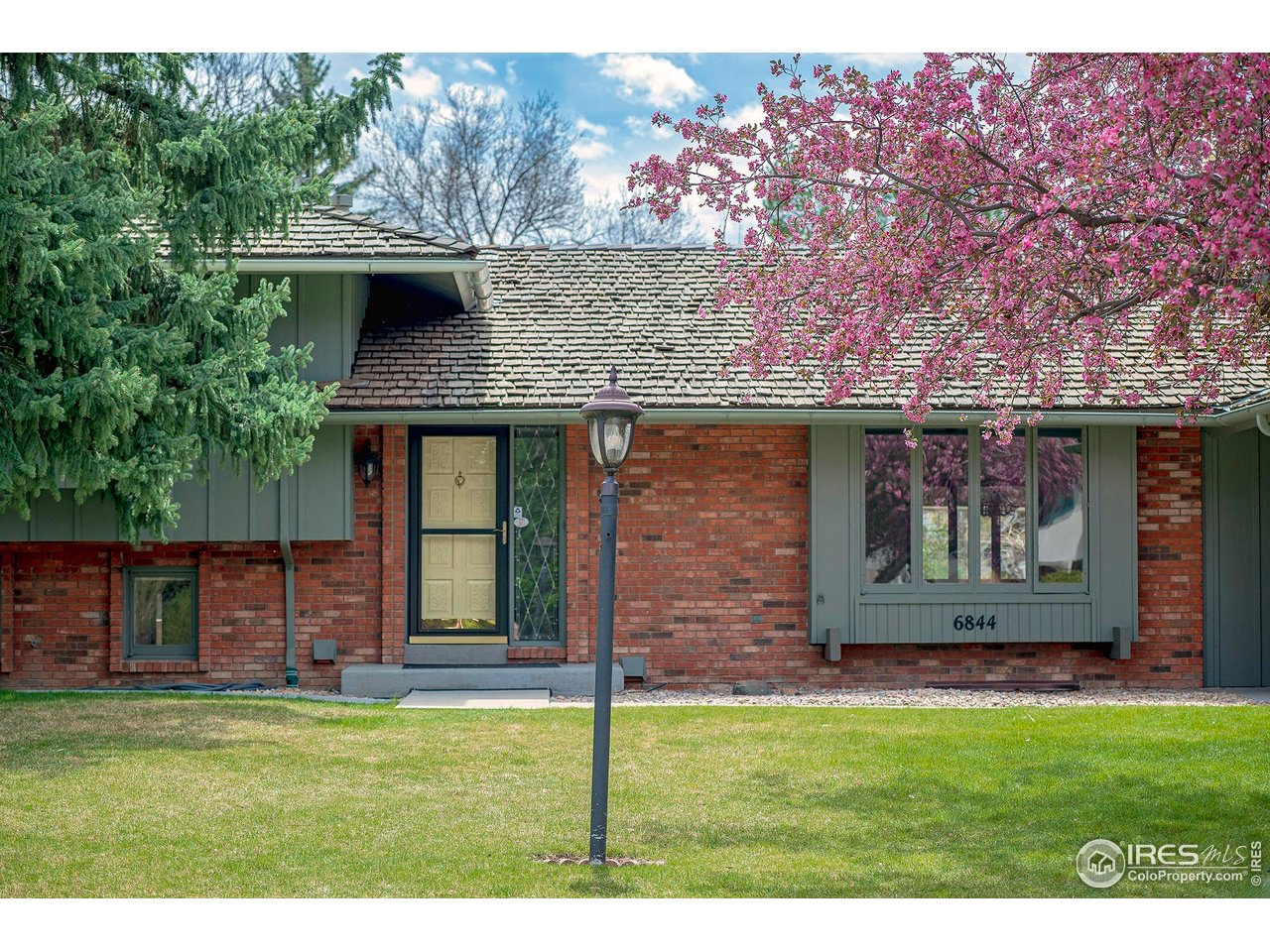 6844 Roaring Fork Trail Boulder, CO 80301 - Photo 26 of 37 a front view of a house with garden