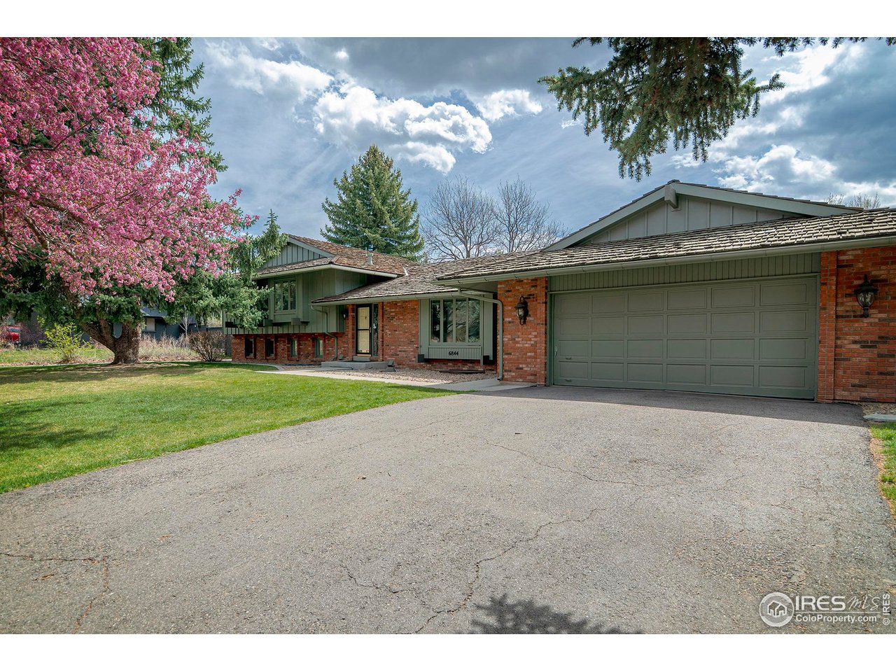 6844 Roaring Fork Trail Boulder, CO 80301 - Photo 27 of 37 a front view of a house with a yard and garage