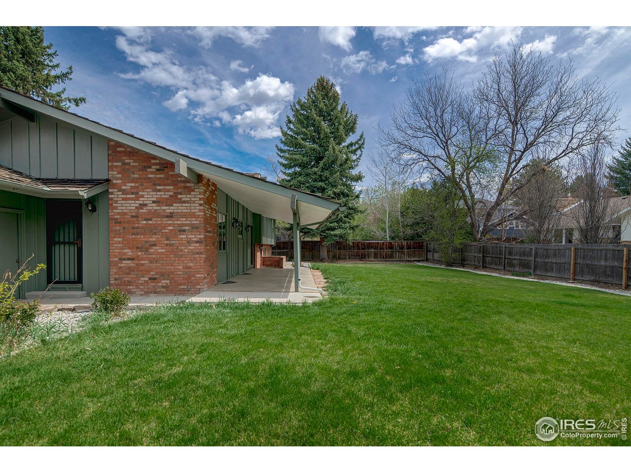 6844 Roaring Fork Trail Boulder, CO 80301 - Photo 28 of 37 a view of backyard with table and chairs and a large tree