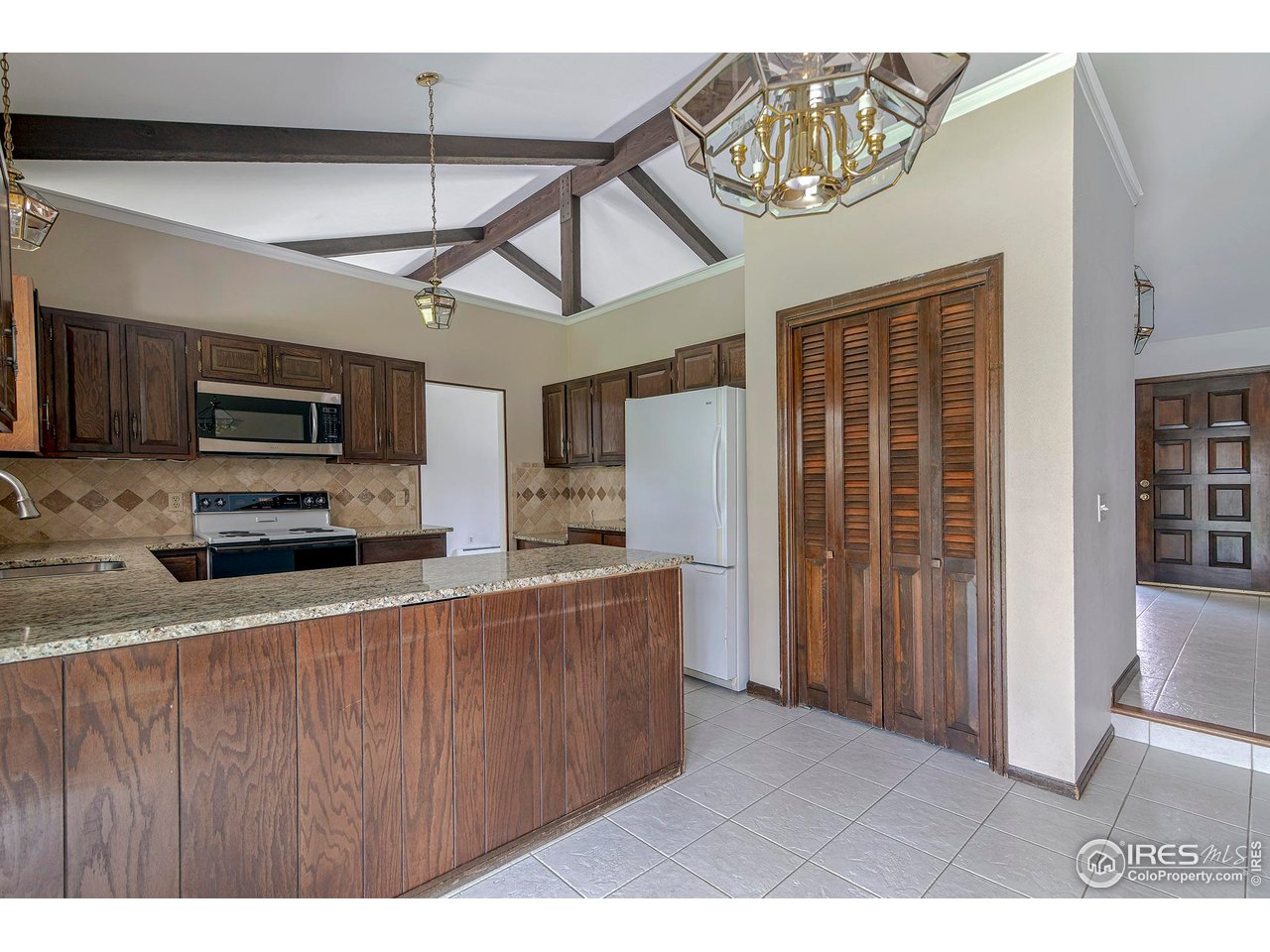 6844 Roaring Fork Trail Boulder, CO 80301 - Photo 9 of 37 a kitchen with stainless steel appliances kitchen island granite countertop a refrigerator a stove top oven a sink and dishwasher