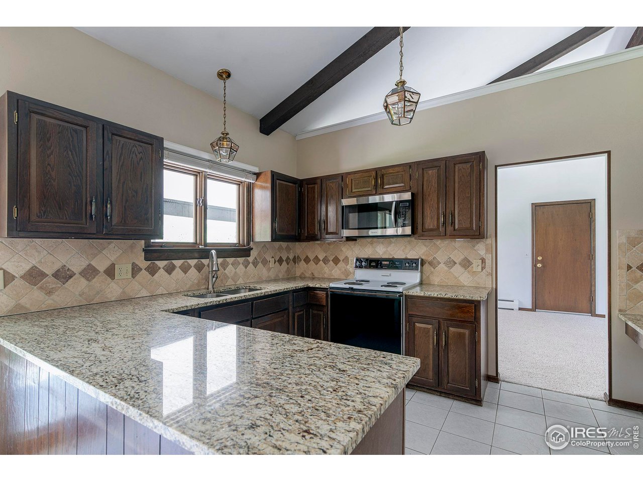6844 Roaring Fork Trail Boulder, CO 80301 - Photo 10 of 37 a kitchen with stainless steel appliances granite countertop a sink stove and microwave