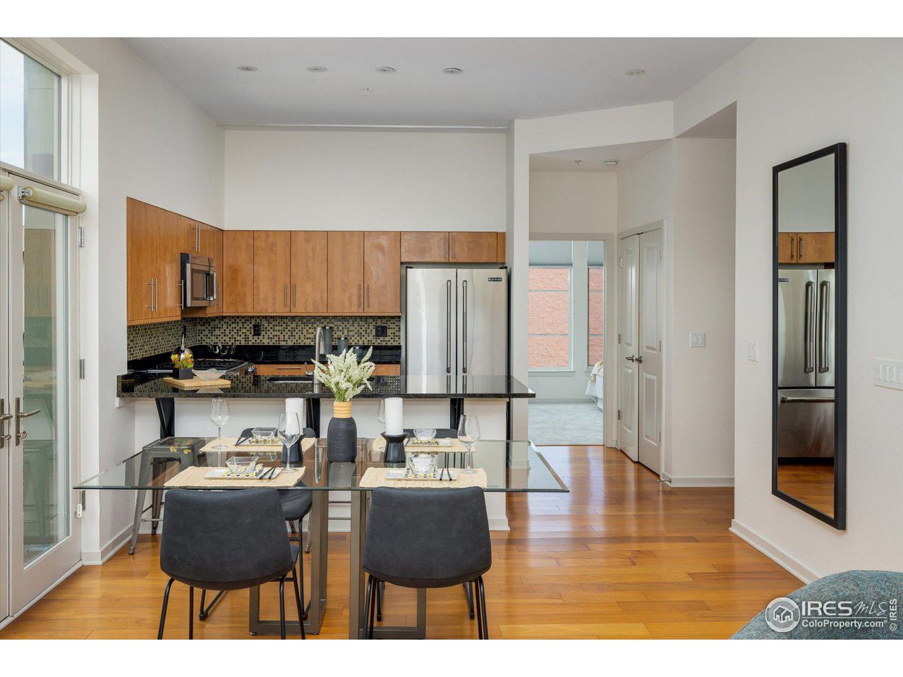 4585 13th Street, Unit D Boulder, CO 80304 - Photo 13 of 30 a kitchen with stainless steel appliances kitchen island granite countertop a refrigerator a stove a sink and white cabinets with wooden floor