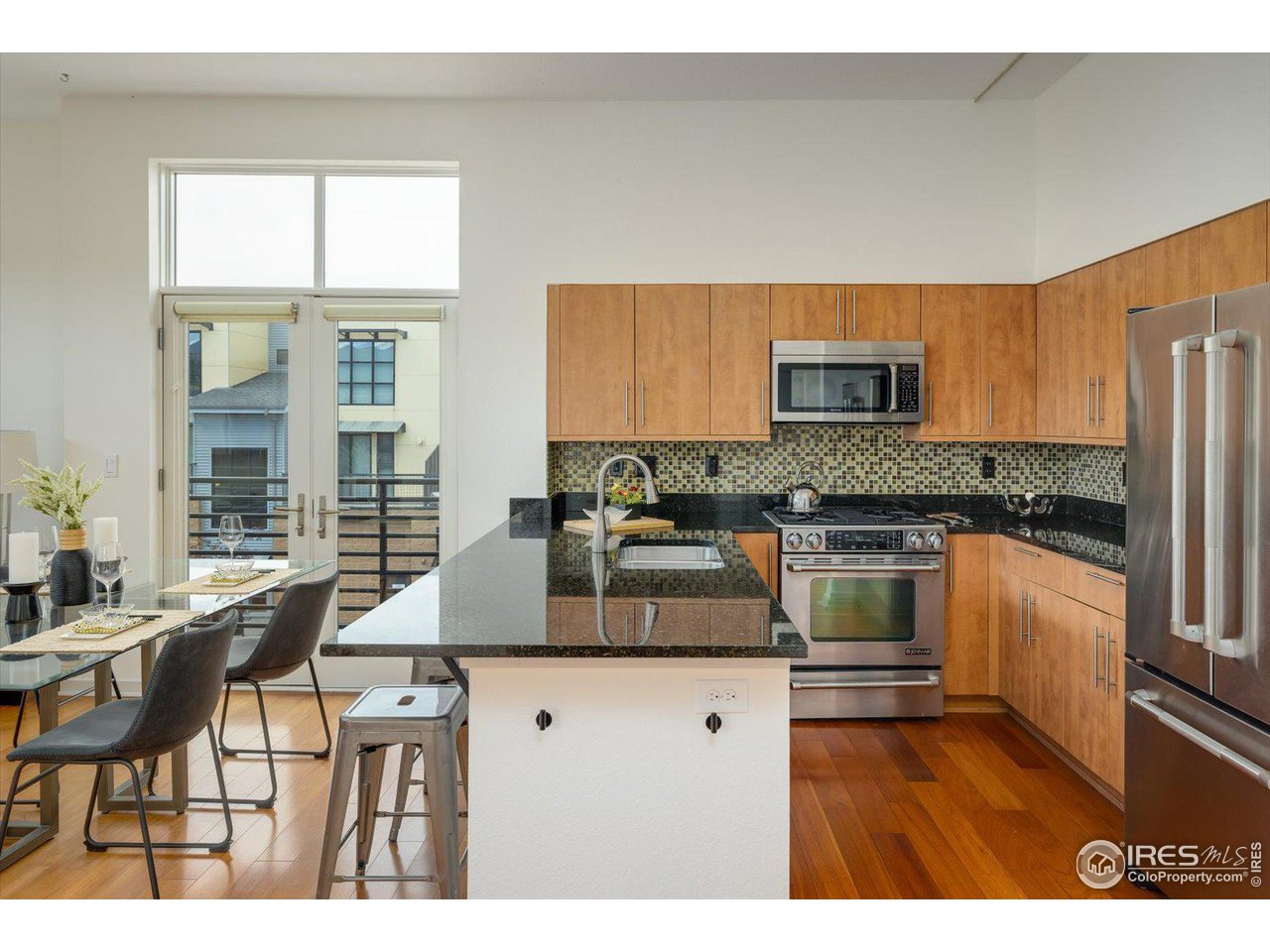 4585 13th Street, Unit D Boulder, CO 80304 - Photo 15 of 30 a kitchen with kitchen island granite countertop a stove top oven a sink a dining table and chairs