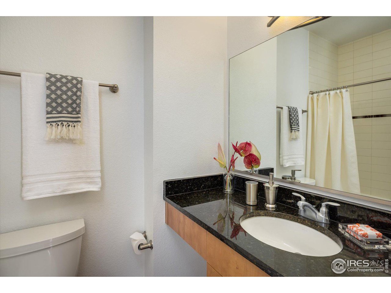 4585 13th Street, Unit D Boulder, CO 80304 - Photo 23 of 30 a bathroom with a granite countertop sink mirror and a toilet
