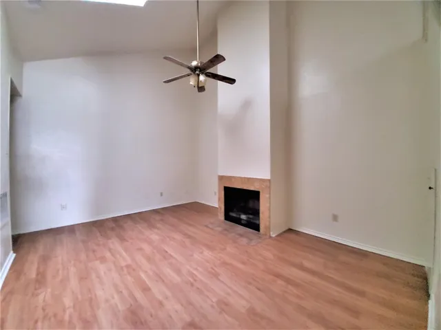 a view of empty room with wooden floor and fireplace