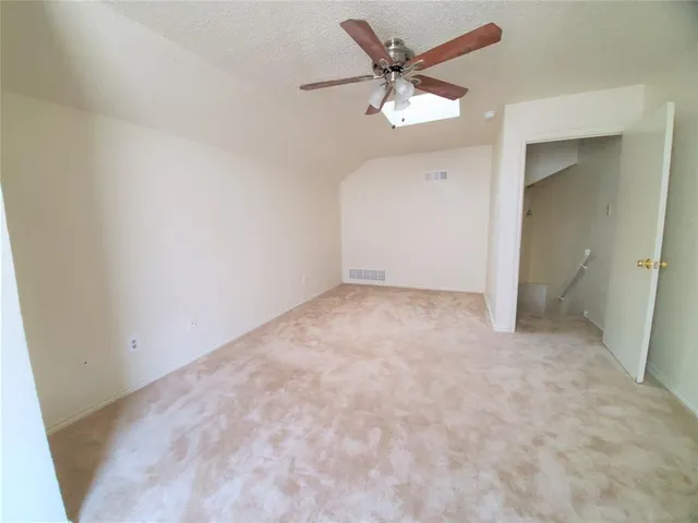 an empty room with a ceiling fan and a window