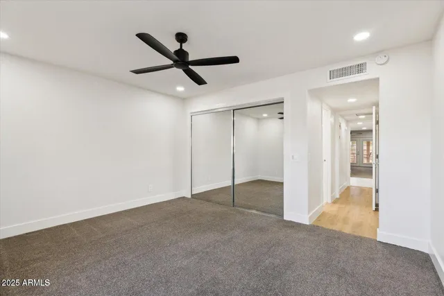 a view of an empty room and a ceiling fan