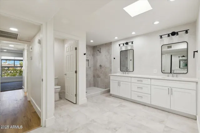 a spacious bathroom with double vanity and mirrors
