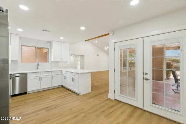 a large white kitchen with a sink a refrigerator and a stove