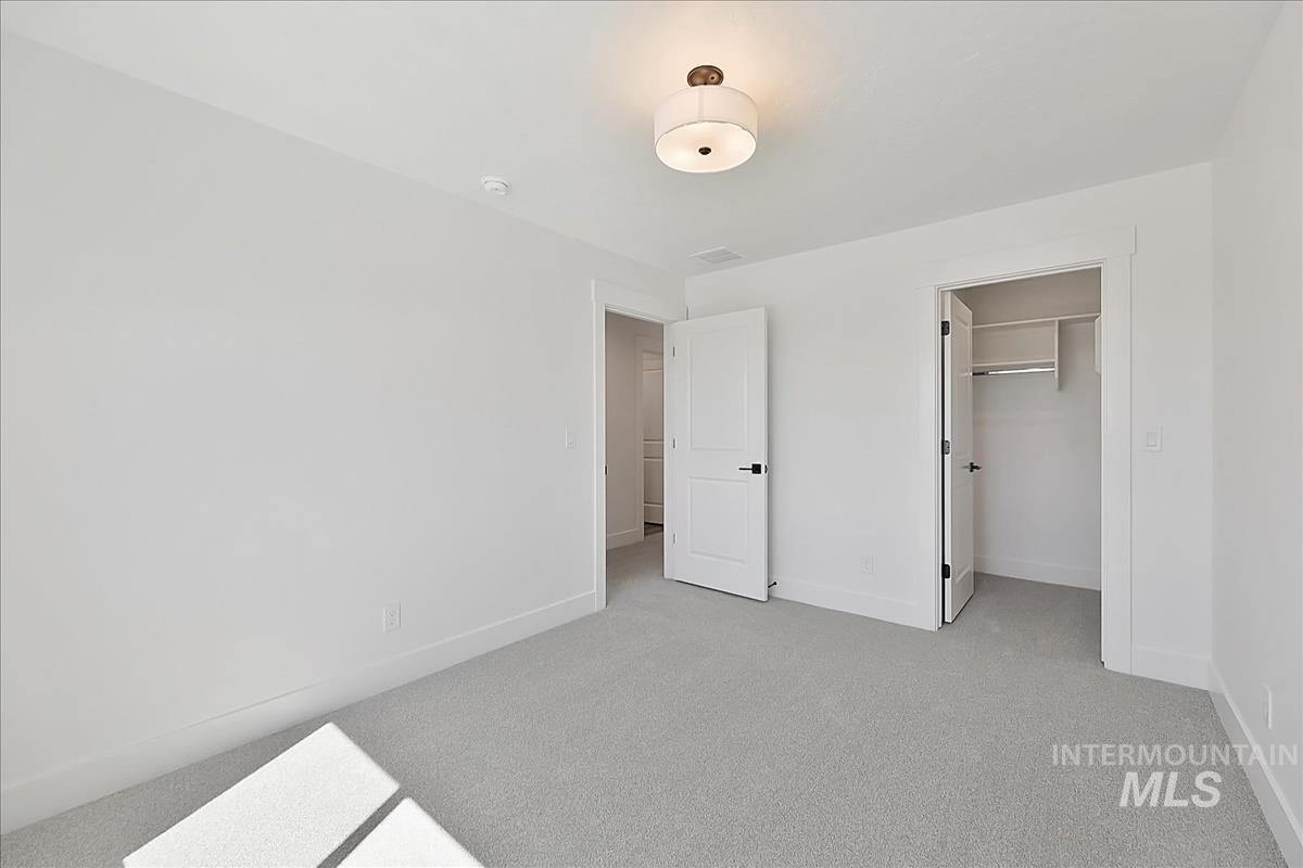 776 South Calhoun Lane Star, ID 83669 - Photo 33 of 49 Neutral-toned room featuring light gray carpeting, white walls, and bright white trim
