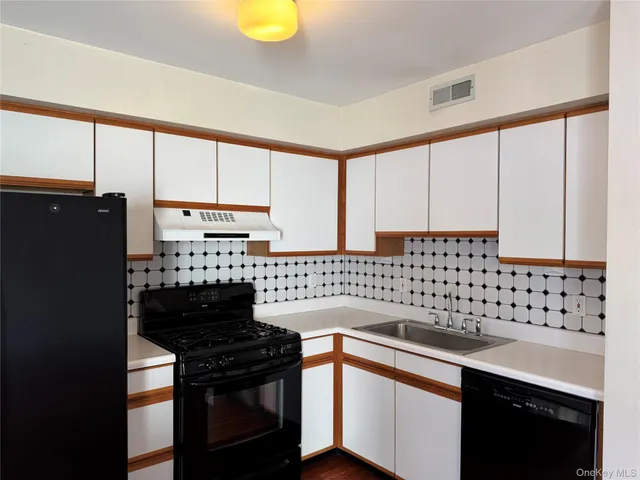 a kitchen with a sink a stove cabinets and a window