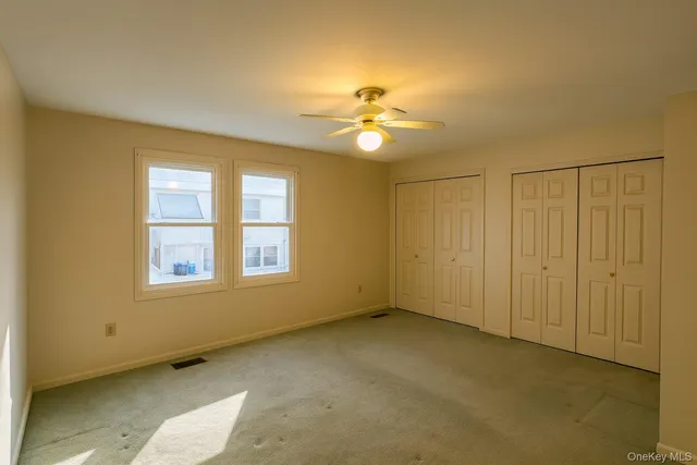 a view of an empty room with a ceiling fan