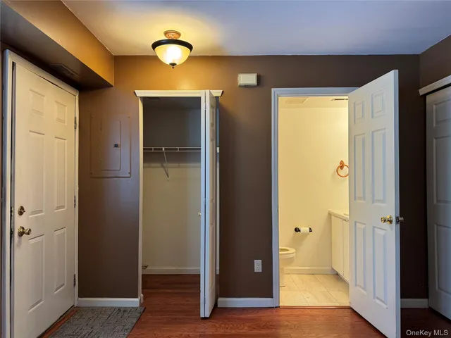 a view of a hallway with wooden floor and closet