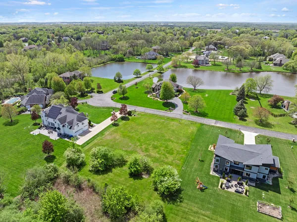 an aerial view of a house with a garden and lake view